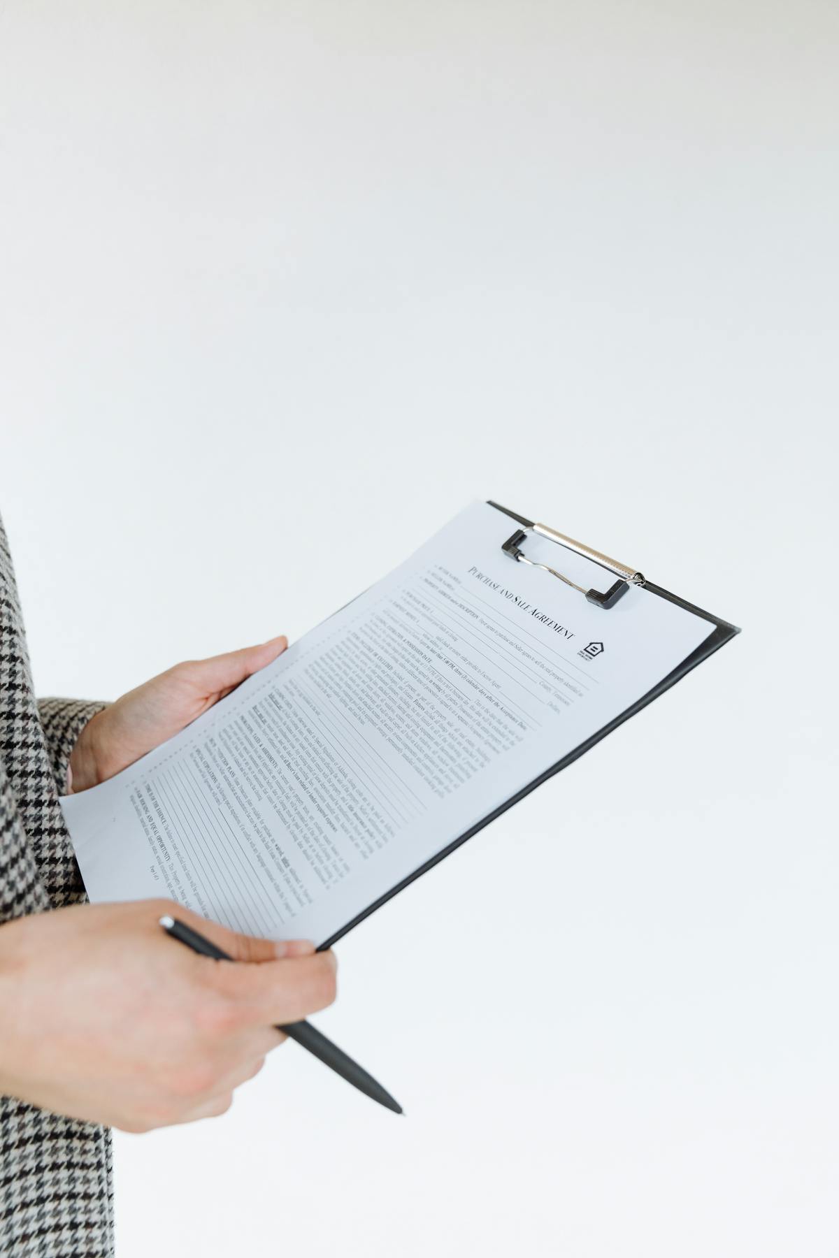 Professional holding filled assessment form on clipboard with pen, representing evaluation process